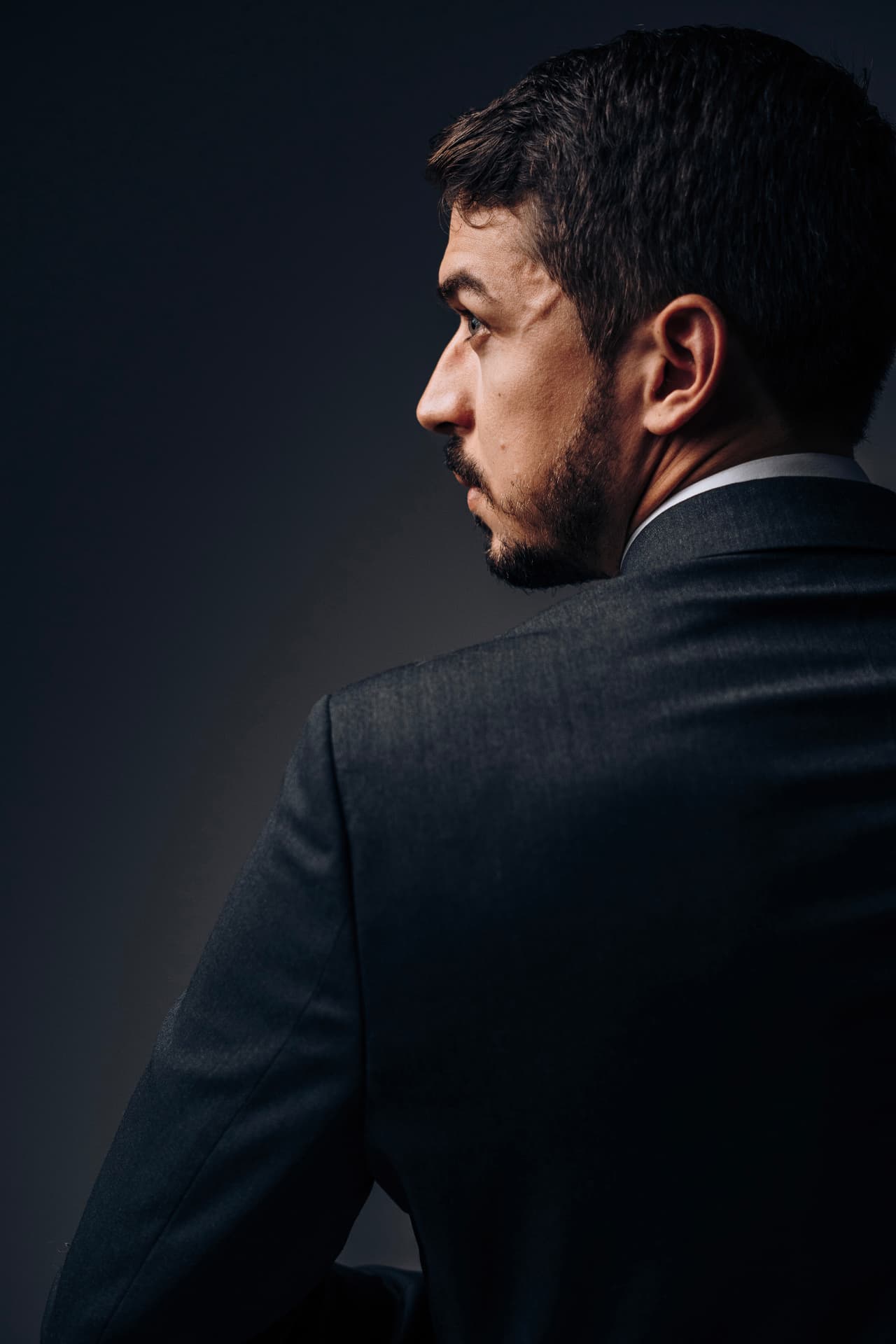 Retrato editorial de perfil de profissional de terno fotografado por Lucian Rabello